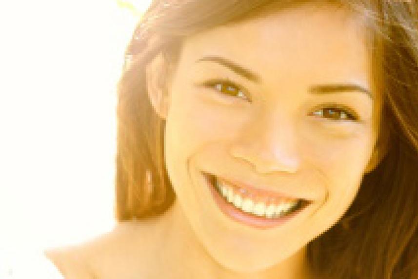 Photo: Smiling woman with bright sun behind her