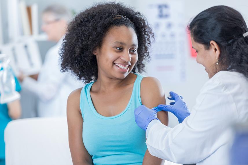 Doctor applying bandaid after a vaccine shot