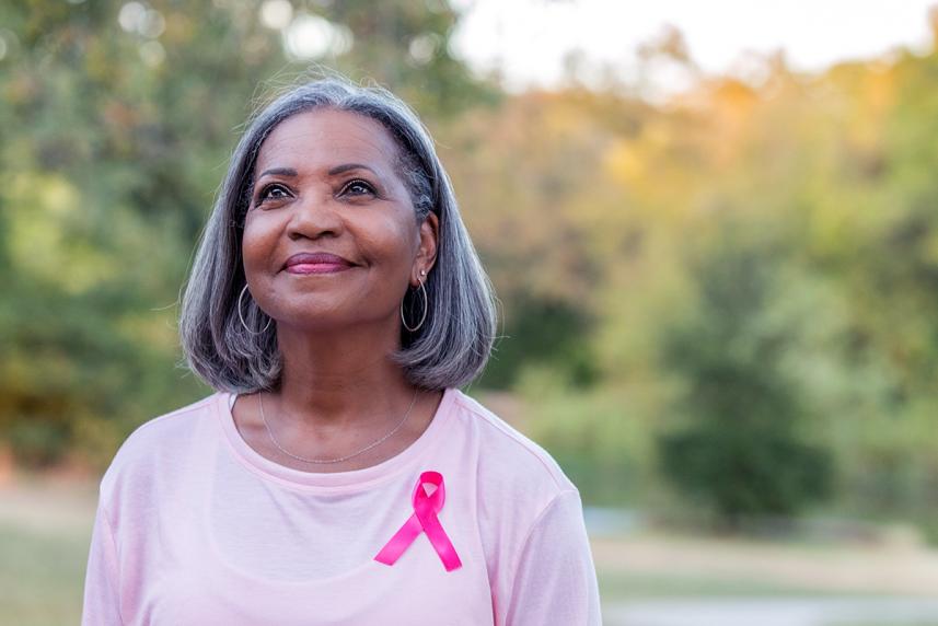 A woman wearing a pink shirt with a pink ribbon