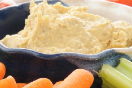 Photo: Bowl of hummus surrounded by crackers and vegetables