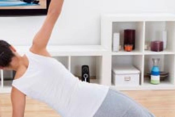 Photo: Woman in fitness wear working out at home