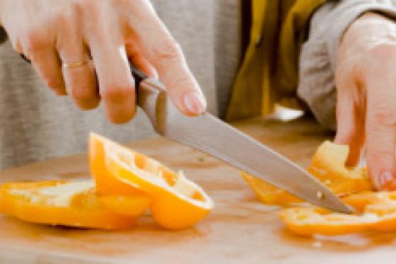 Photo: Woman slicing a yellow pepper