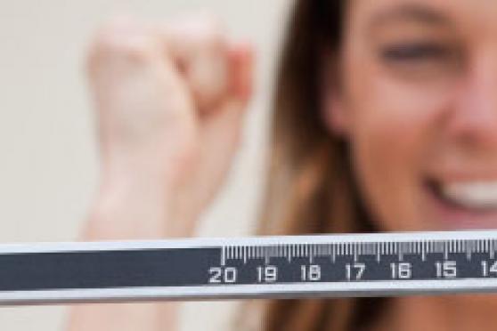 Photo: Woman on a scale excited about weight loss results