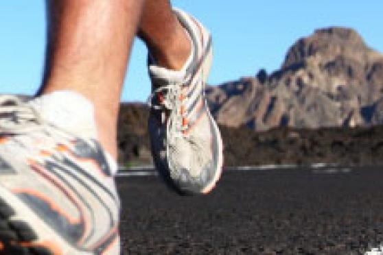 Photo: Close-up of running feet with mountain in background