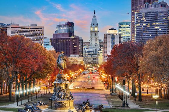 Photo of a city with orange and yellow leaves on trees