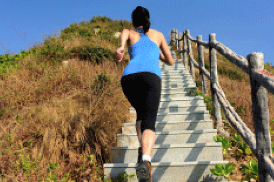 Photo: Fit woman running up a long set of outdoor stairs on a mountain
