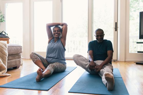 Couple doing yoga for secrets to getting fit after 60