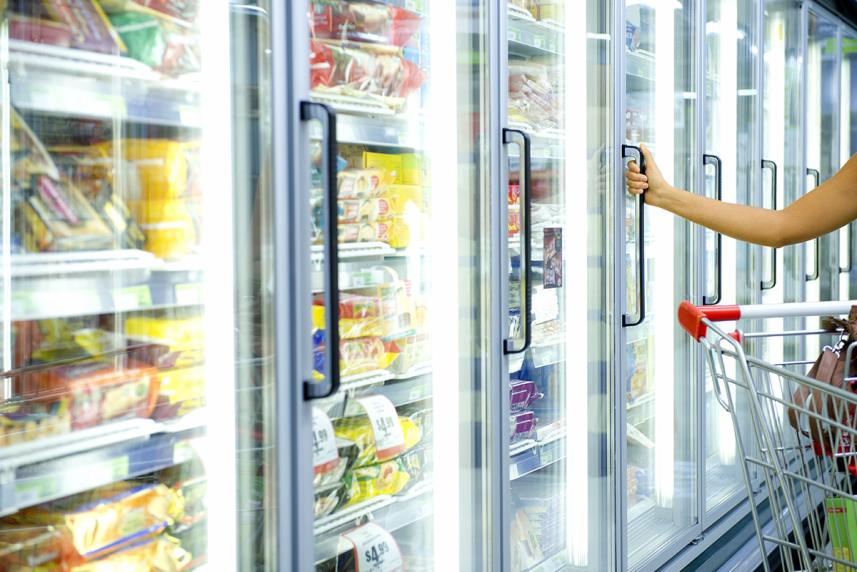 Hand opening door of freezer at supermarket