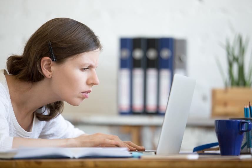 Woman straining to see her laptop