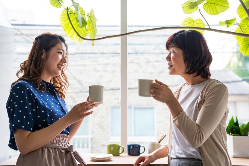 A mother and her adult daughter having coffee together