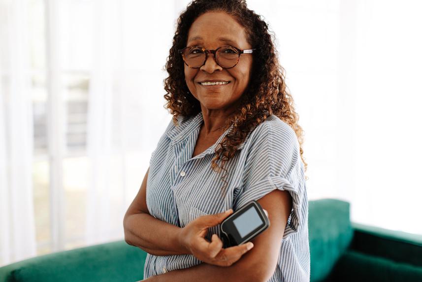 A woman holding a diabetes device on her arm