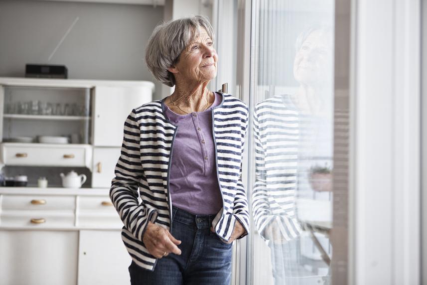 Woman looking out a glass door