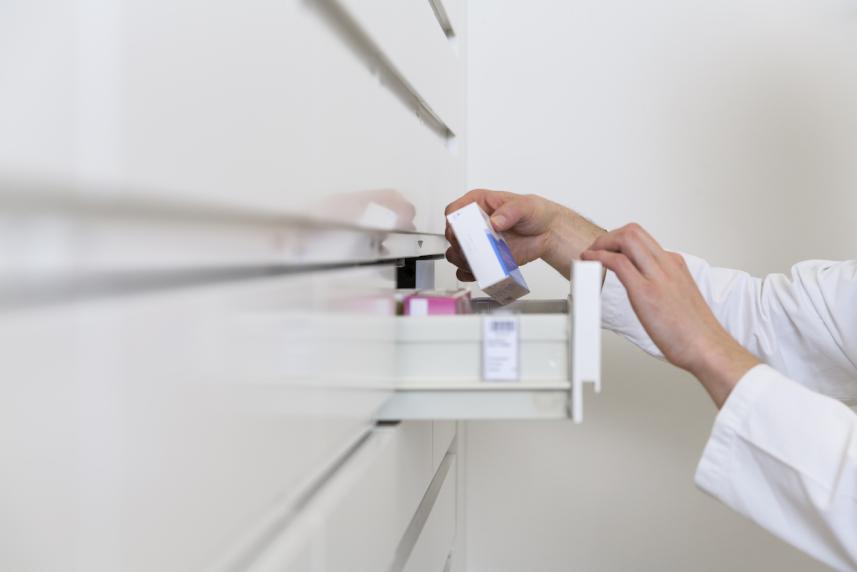 women looking through pills in cabinet