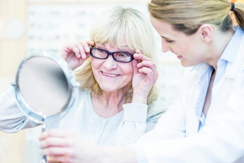 Photo: Older woman trying on glasses