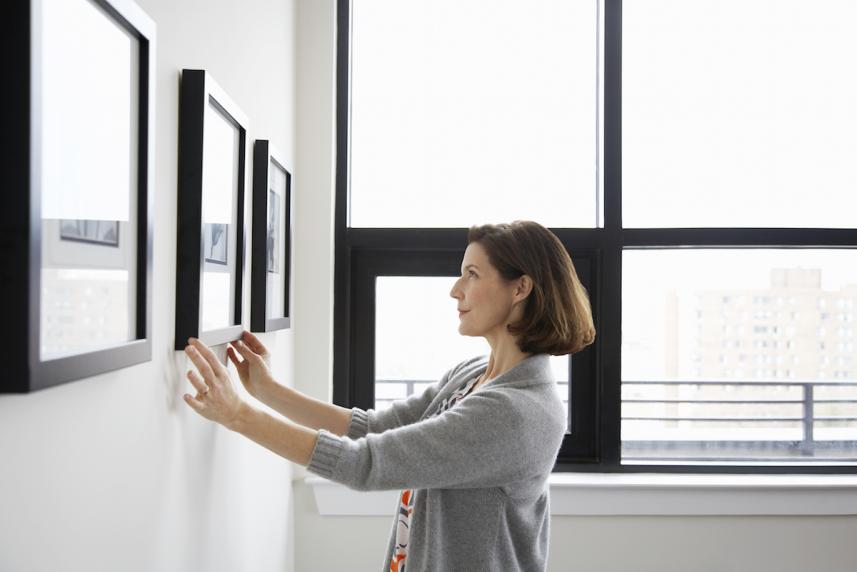 woman hanging up art