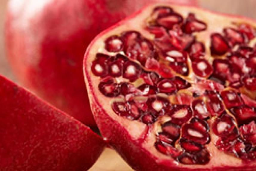 A sliced pomegranate, with its shiny red seeds exposed