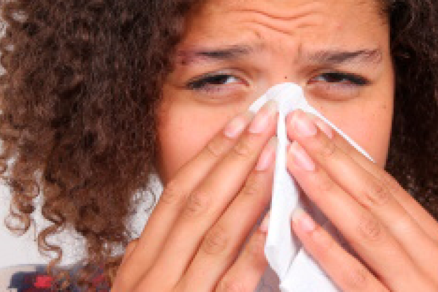 Photo: Young woman blowing nose