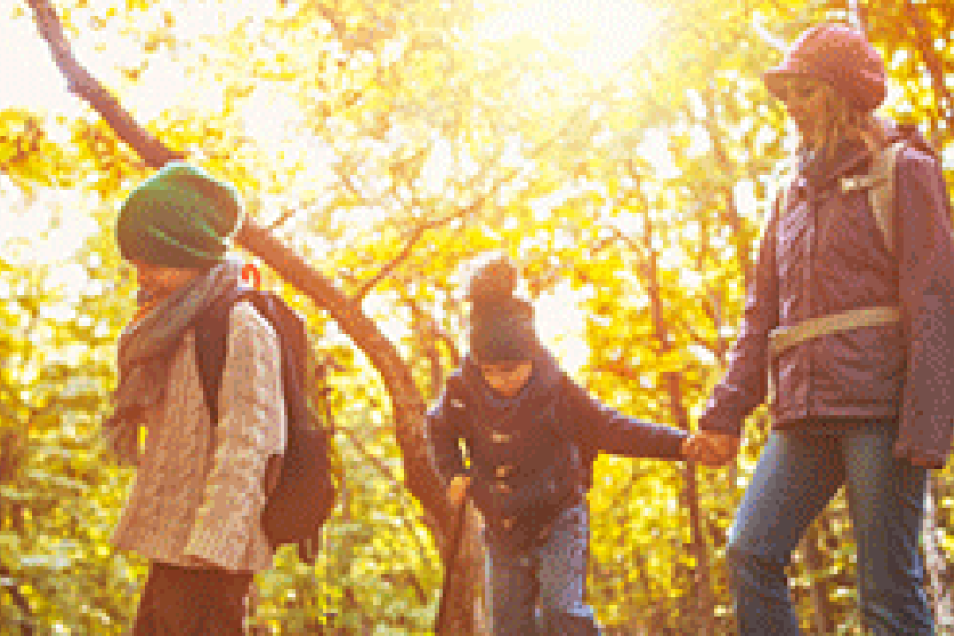 Photo: Mother and children dressed warm walking in the woods