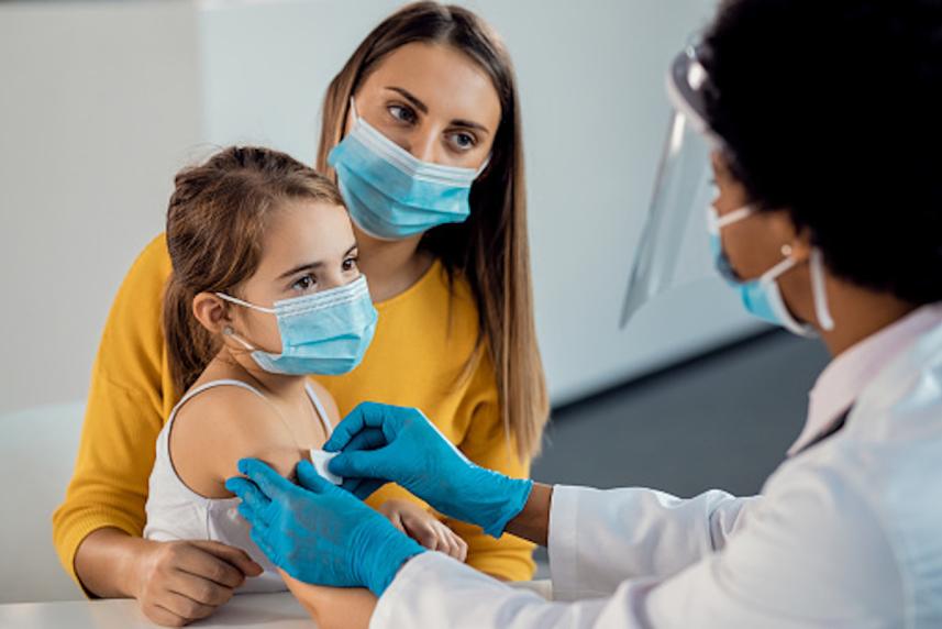 A recently vaccinated child with their parent and doctor