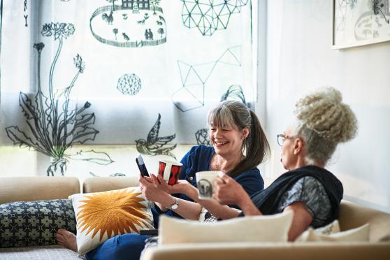 A mother and daughter share a laugh on their couch