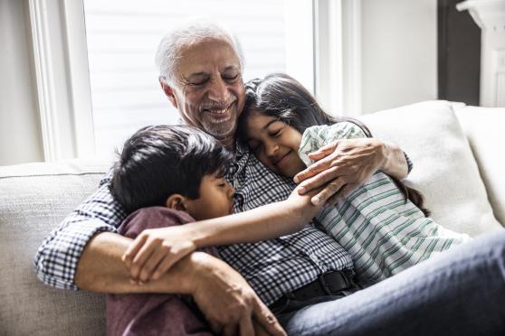 A man hugs his grandchildren