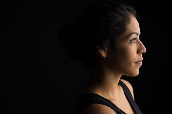 Woman behind a dark background