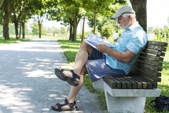 older man sitting down and reading the newspaper