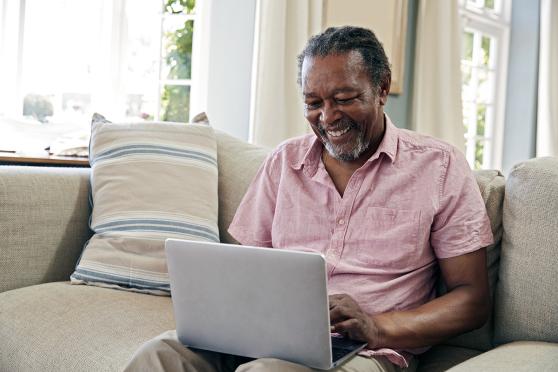 A man smiling at a laptop