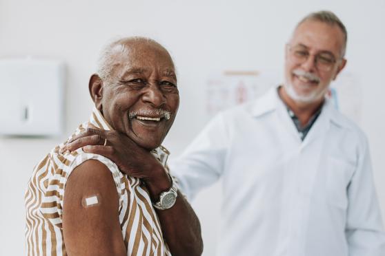 Man with bandaid on his upper shoulder after getting a vaccine