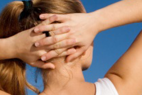 Photo: Rear view of woman stretching with hands clasped behind her head