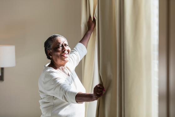 Woman opening curtains