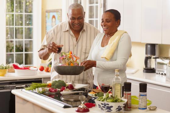 Photo: Man and woman cooking a healthy meal together.