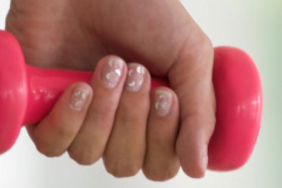 Photo: Close-up of woman's hand holding a small dumbbell